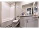 Bright bathroom featuring a shower-tub combo with white tile and a granite-topped vanity at 7721 Sheliak St, North Las Vegas, NV 89084