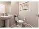 Cozy powder room with pedestal sink, toilet, and decorative world map at 7721 Sheliak St, North Las Vegas, NV 89084