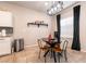 Dining area featuring modern light fixtures, a stylish dining table, and a window with dark curtains for a cozy ambiance at 7721 Sheliak St, North Las Vegas, NV 89084