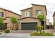 Charming two-story home featuring a two-car garage and a well-maintained front yard with young trees and mature landscaping at 7721 Sheliak St, North Las Vegas, NV 89084