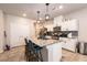 Modern kitchen featuring white cabinets, granite countertops, stainless steel appliances, and an island with bar seating at 7721 Sheliak St, North Las Vegas, NV 89084