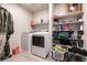Convenient laundry room with a washer, dryer, and shelving for storage solutions at 7721 Sheliak St, North Las Vegas, NV 89084