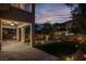 Beautiful backyard at dusk with landscape lighting, artificial turf, and a covered patio at 7878 Brianna Cheerful Ave, Las Vegas, NV 89178