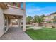 Large backyard featuring artificial turf, paver patio, and a covered patio with ceiling fan at 7878 Brianna Cheerful Ave, Las Vegas, NV 89178