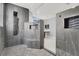 Elegant bathroom featuring a tiled shower with seating, rainfall shower-head and stone pebble floor at 7878 Brianna Cheerful Ave, Las Vegas, NV 89178