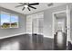 Bright bedroom features dark wood floors, closet with sliding doors, and a ceiling fan at 7878 Brianna Cheerful Ave, Las Vegas, NV 89178
