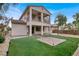 Two-story home featuring a balcony, covered patio, and landscaped backyard with artificial turf at 7878 Brianna Cheerful Ave, Las Vegas, NV 89178