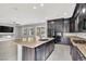 Gourmet kitchen featuring dark cabinetry, granite countertops, and stainless steel appliances at 7878 Brianna Cheerful Ave, Las Vegas, NV 89178