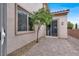 Back patio featuring brick pavers, a sliding glass door and a mature tree with blooming yellow flowers at 7878 Brianna Cheerful Ave, Las Vegas, NV 89178