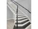 Classic black and white staircase with modern railings, offering an elegant transition between floors at 7878 Brianna Cheerful Ave, Las Vegas, NV 89178