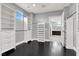 Bright walk-in closet with black wood floors, custom storage solutions and a glimpse of the bathroom beyond at 7878 Brianna Cheerful Ave, Las Vegas, NV 89178