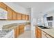 Kitchen with wood cabinets, granite countertops, and modern appliances, with an open view of the adjacent living area at 7990 Timber Horn Ct, Las Vegas, NV 89147