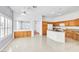Bright open kitchen with wood cabinets, white appliances, and a central island for added workspace at 7990 Timber Horn Ct, Las Vegas, NV 89147