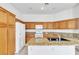 Bright kitchen with wood cabinets, white appliances, granite countertops, and a functional central island at 7990 Timber Horn Ct, Las Vegas, NV 89147