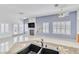 Spacious open-concept living space with tile flooring, a fireplace, and a partial kitchen view at 7990 Timber Horn Ct, Las Vegas, NV 89147
