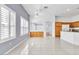 Bright living space featuring tile flooring, plantation shutters, an open layout, and partial kitchen view at 7990 Timber Horn Ct, Las Vegas, NV 89147