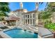 The backyard boasts a sparkling pool, patio area, and lush landscaping at 8051 Castle Pines Ave, Las Vegas, NV 89113