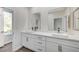 Bathroom with double sinks, white cabinets with gold hardware and neutral countertops at 8051 Castle Pines Ave, Las Vegas, NV 89113