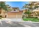 Inviting two-story home featuring a red tile roof, mature landscaping and a spacious driveway leading to a two-car garage at 8051 Castle Pines Ave, Las Vegas, NV 89113