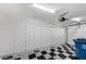Well-organized garage with ample built-in storage cabinets and stylish checkerboard flooring at 8051 Castle Pines Ave, Las Vegas, NV 89113