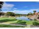 Scenic golf course view featuring a lush green fairway with a water hazard and beautiful landscaping around the course at 8051 Castle Pines Ave, Las Vegas, NV 89113
