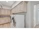 Well-lit laundry room with ample cabinet space, modern appliances, and stylish backsplash at 8051 Castle Pines Ave, Las Vegas, NV 89113