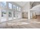 Open-concept living room with soaring ceilings, a wall of windows, and wood flooring, offering abundant natural light and space at 8051 Castle Pines Ave, Las Vegas, NV 89113