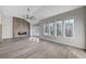 Large living room featuring wood fireplace, large windows, and modern fan at 8051 Castle Pines Ave, Las Vegas, NV 89113