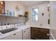 Functional laundry room with modern appliances, storage cabinets, and a sink at 8171 California Pine St, Las Vegas, NV 89166