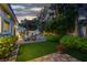 Spacious backyard with lush greenery, brick-paved patio, and a tranquil water feature at 8969 Rivers Edge Dr, Las Vegas, NV 89117