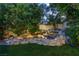 Beautiful rock water feature enhances the serene backyard ambiance with lush greenery at 8969 Rivers Edge Dr, Las Vegas, NV 89117