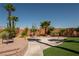 Backyard featuring a basketball hoop, walkway, palm trees, and artificial grass at 9012 Alpine Peaks Ave, Las Vegas, NV 89147