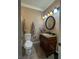 Elegant bathroom featuring a decorative wood vanity, granite countertop, oval mirror, and stylish lighting at 9012 Alpine Peaks Ave, Las Vegas, NV 89147
