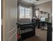 Cozy bedroom featuring neutral carpet, a work desk, and large sunlit window at 9012 Alpine Peaks Ave, Las Vegas, NV 89147