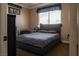 Cozy bedroom featuring a bed with a gray comforter, large window, and carpeting at 9012 Alpine Peaks Ave, Las Vegas, NV 89147