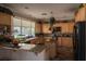 Bright kitchen featuring wooden cabinets, granite countertops, island, and stainless steel appliances at 9012 Alpine Peaks Ave, Las Vegas, NV 89147
