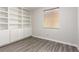 Bedroom with wood look floors, built-in bookshelves, and a window at 9604 Windom Point Ave, Las Vegas, NV 89129