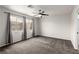 Spacious bedroom with carpet flooring, a ceiling fan, and large windows at 9604 Windom Point Ave, Las Vegas, NV 89129