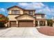 A tan two story home with a three car garage and manicured landscape at 9604 Windom Point Ave, Las Vegas, NV 89129