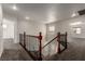 Bright hallway between rooms with wood and iron railing and carpet at 9604 Windom Point Ave, Las Vegas, NV 89129