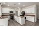 Bright kitchen features white cabinets, stainless steel appliances, and an island with a breakfast bar at 9604 Windom Point Ave, Las Vegas, NV 89129