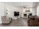 Cozy living room with a fireplace, ceiling fan, and wood look floors at 9604 Windom Point Ave, Las Vegas, NV 89129