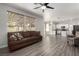 Living room with wood look floors, ceiling fan, and an adjacent kitchen at 9604 Windom Point Ave, Las Vegas, NV 89129
