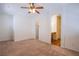 Spacious bedroom with soft carpet, ceiling fan, and convenient access to a private bathroom at 961 Wembly Hills Pl, Henderson, NV 89011