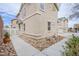 Exterior view of a tan two-story home with rock landscaping and sidewalks at 961 Wembly Hills Pl, Henderson, NV 89011
