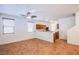 Open-concept living area with tile flooring, ceiling fan, and kitchen view at 961 Wembly Hills Pl, Henderson, NV 89011