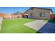Backyard with well-maintained artificial turf, seating area, and fenced perimeter at 10281 Sequoia Falls Pl, Las Vegas, NV 89149