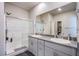 Bathroom featuring double sinks, granite countertops, and a walk-in shower at 10281 Sequoia Falls Pl, Las Vegas, NV 89149