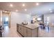 Spacious open kitchen showcasing an island with a sink and adjacent dining and living areas at 10281 Sequoia Falls Pl, Las Vegas, NV 89149