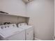 Functional laundry room with white washer and dryer units and overhead shelving at 10281 Sequoia Falls Pl, Las Vegas, NV 89149